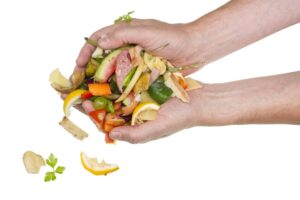 Hand holding various food scraps.